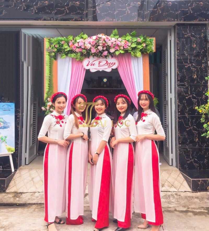 Áo dài bưng quả màu trắng phối với hoa đỏ